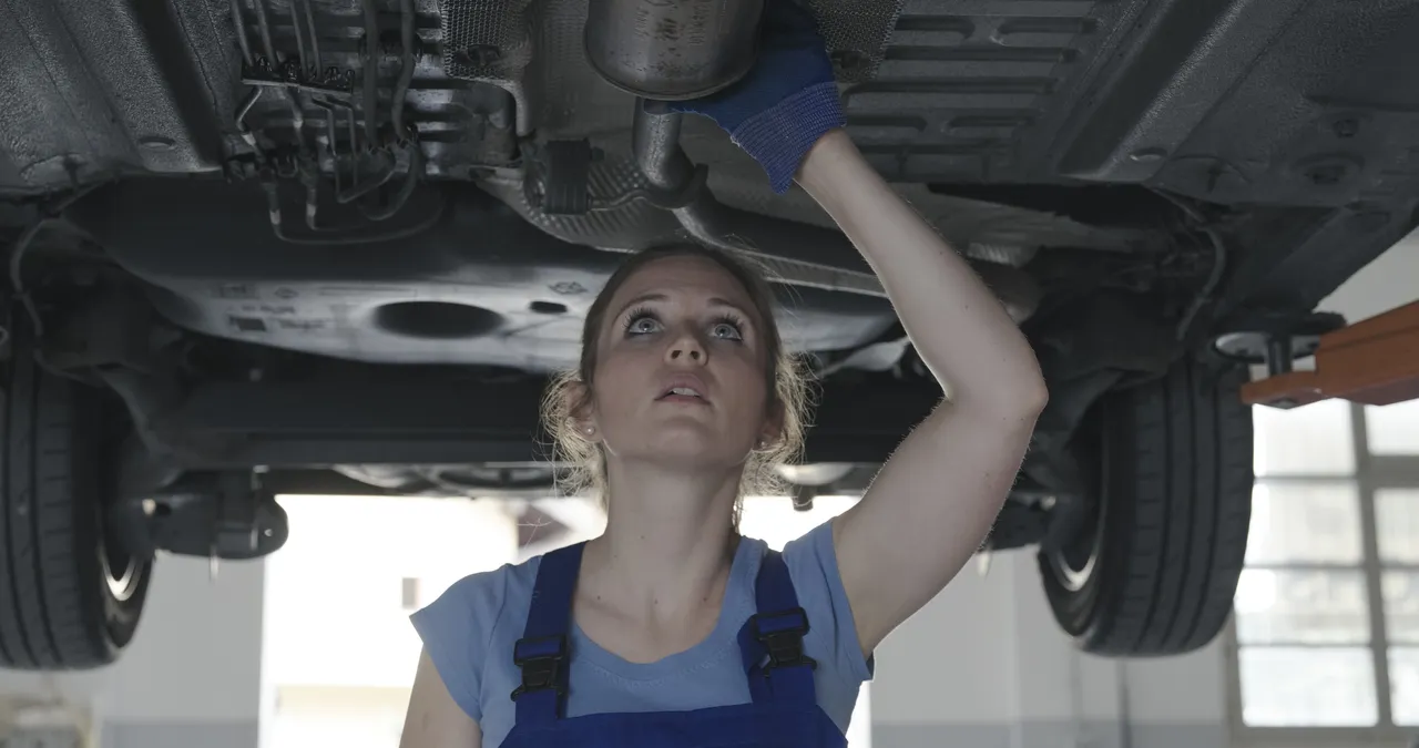 female-mechanic-working-under-a-car-2023-11-27-04-58-05-utc